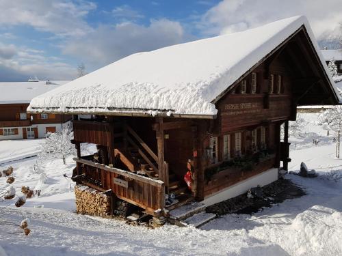 a small wooden cabin with snow on the roof at B & B Brienz in Brienz
