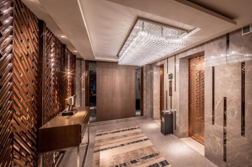 a lobby with a staircase and a wall of wine bottles at Braira Al Olaya in Riyadh