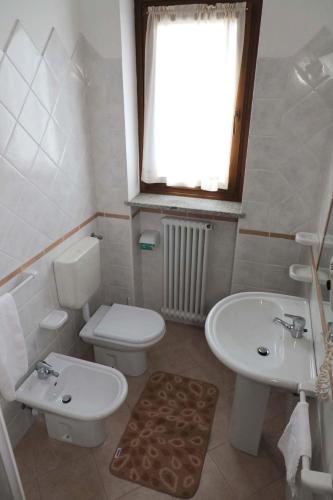 a white bathroom with a toilet and a sink at Hotel Ristorante Château in Aymavilles