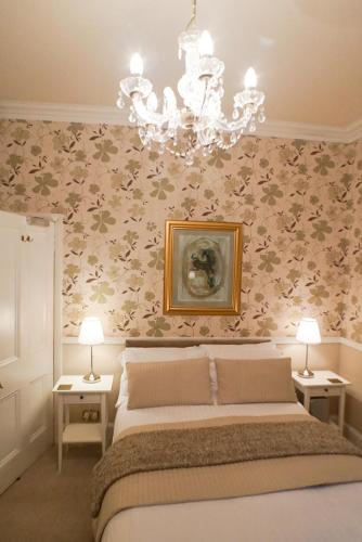a bedroom with a bed and a chandelier at Hedley Villa Guest House in Leamington Spa