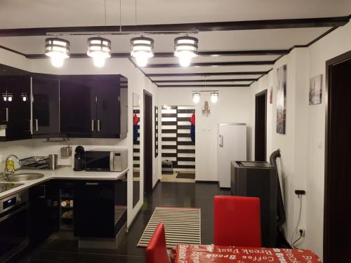 a kitchen with black cabinets and a red chair at Sweet Apartment in Ramingstein