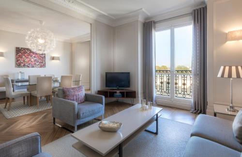 ein Wohnzimmer mit einem Sofa und einem Esszimmer in der Unterkunft Résidence Charles Floquet in Paris