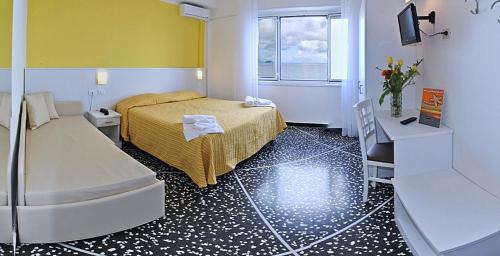 a bedroom with a bed and a window and a table at Hotel Bristol in Laigueglia