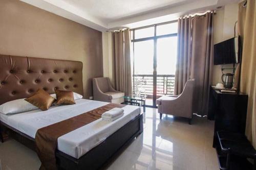 a bedroom with a large bed and a large window at Adelaida Pensionne Hotel in Bantayan Island