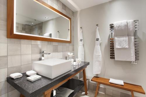 
a bathroom with a sink, towel rack, and towel dispenser at Kube Saint-Tropez in Saint-Tropez
