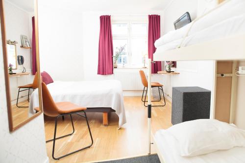 a room with a table and chairs and a mirror at STF Hotel Zinkensdamm in Stockholm
