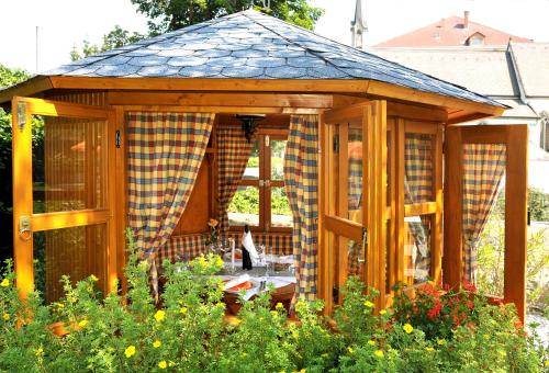 a wooden gazebo in the middle of a garden at Hotel Zum Goldenen Hirschen in Freistadt