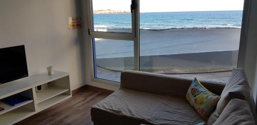 a living room with a couch and a view of the ocean at Casa Playa Ondina in Gáldar