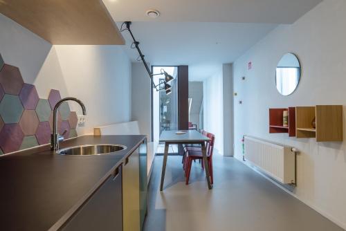 a kitchen with a sink and a table at The Hide in Ghent