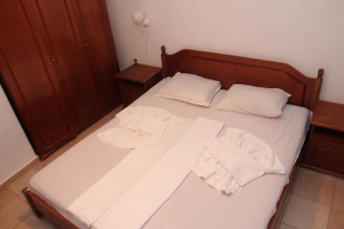 a bed with white sheets and two towels on it at Hotel Briz 3 - Free Parking in Varna City