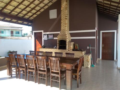 a dining room with a table and chairs and a fireplace at Frente a Praia. Ótima casa barra de são João Rio das ostras,fino acabamento in Barra de São João