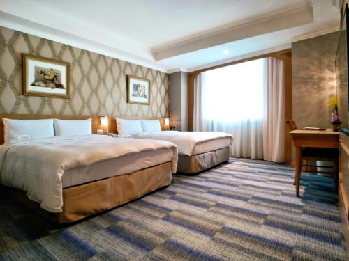 a hotel room with two beds and a desk at Beauty Hotels - Star Beauty Resort in Taipei
