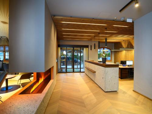 an office lobby with a counter and a fireplace at Hotel Bergzeit in Grossarl