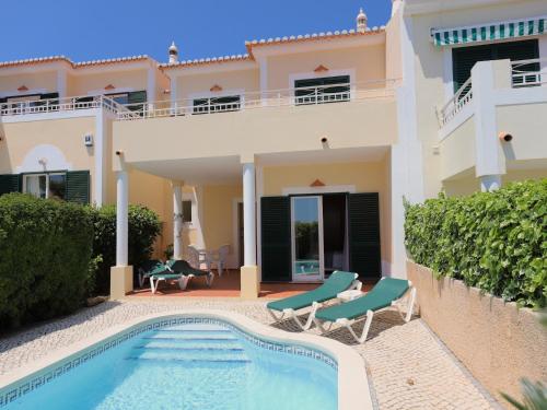 a villa with a swimming pool in front of a house at OCEAN VIEW VILLA BELAMAR in Luz
