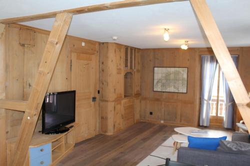 a living room with wood paneling and a tv at Hotel Wynegg in Klosters