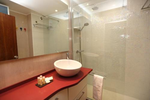 y baño con lavabo y ducha acristalada. en Like-home Sea View Apt, en Carcavelos