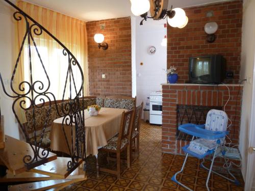 ein Esszimmer mit einem Tisch und einem Kamin in der Unterkunft House Sophie in Vonyarcvashegy