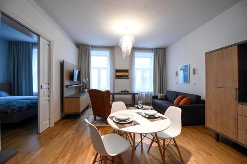 a living room with a table and chairs in a room at City Centre Chic Apartment Ljubljana 2/4 in Ljubljana