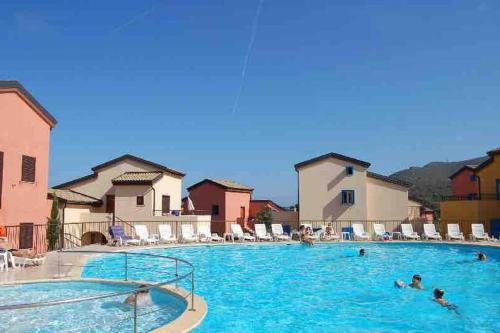 un groupe de personnes se baignant dans une grande piscine dans l'établissement T3 Duplex tout confort - piscine - proche plage - 6 personnes, à Palasca