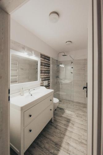 a white bathroom with a sink and a shower at Leśniki in Babimost