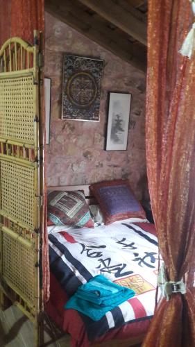 ein Schlafzimmer mit einem Bett in einem Blockhaus in der Unterkunft El Templete de San Miguel in San Miguel de Bernúy