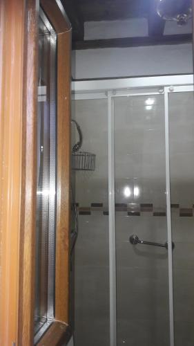 uma cabina de duche com uma porta de vidro na casa de banho em El Templete de San Miguel em San Miguel de Bernúy