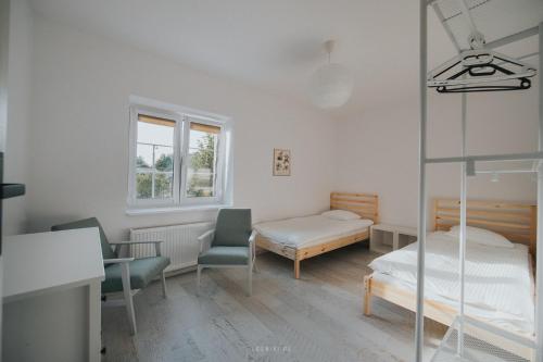 a bedroom with a bed and a bed and chairs at Leśniki in Babimost