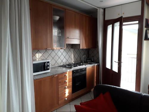 uma cozinha com armários de madeira e um forno com placa de fogão em IEO - HUMANITAS - MILANO CENTRO a 15 minuti em Locate di Triulzi