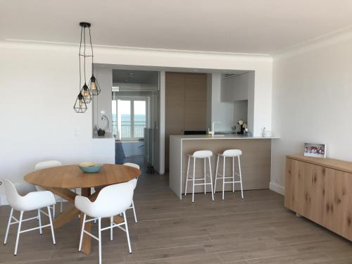 een keuken en eetkamer met een tafel en stoelen bij Appartement Belle Mer - Adults Only in Middelkerke