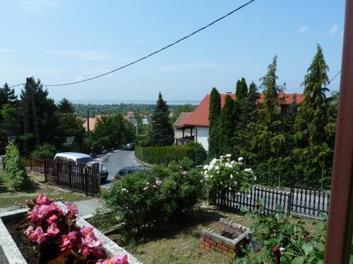 a view of a house with a fence and flowers at House Sophie in Vonyarcvashegy
