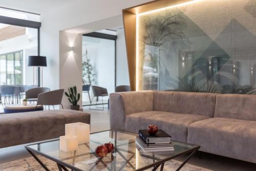 a living room with a couch and a glass table at Bordoy Alcudia Port Suites - Adults Only in Port d'Alcudia