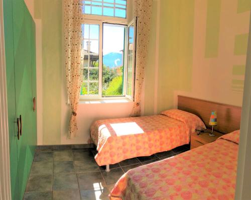 una camera con due letti e una finestra di Appartamento Tennis a Cannero Riviera