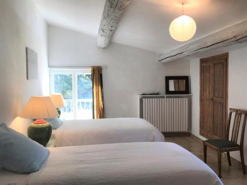 a bedroom with two beds and a window at Oustau du Ventoux in Bédoin