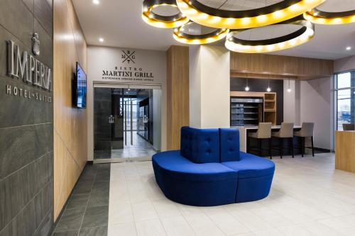 a blue chair in the lobby of a restaurant at Imperia Hôtel et Suites Boucherville in Boucherville