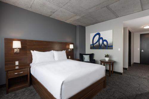 a hotel room with a large bed and a desk at Imperia Hôtel et Suites Boucherville in Boucherville