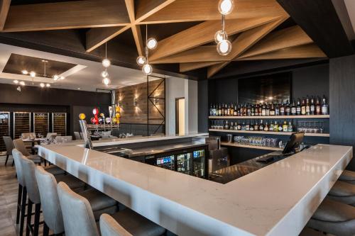 a bar with a long counter and chairs at Imperia Hôtel et Suites Boucherville in Boucherville