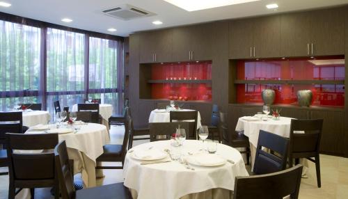 een restaurant met tafels en stoelen met witte tafelkleden bij Hotel Tiffany & Resort in Cesenatico