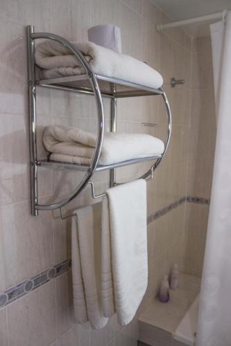 a bathroom with a towel rack with towels at Hosteria Solar de la Costa in Puerto Madryn