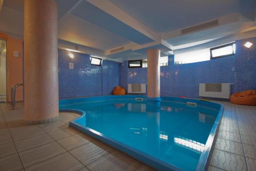 a large swimming pool in a room with blue walls at Complex Turistic Le Baron in Vatra Dornei