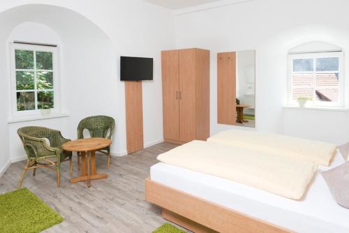 a bedroom with a bed and a table and chairs at Hotel Garni BURG WALDENSTEIN in Rudersberg