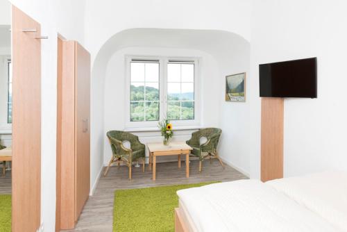 um quarto com uma mesa, cadeiras e uma cama em Hotel Garni BURG WALDENSTEIN em Rudersberg