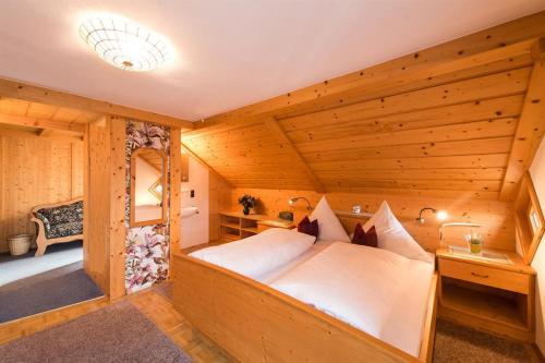 1 dormitorio con 1 cama en una habitación de madera en Landhaus Beßler, en Bad Hindelang