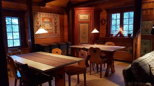 a dining room with two tables and chairs and windows at Vargheden Bed & Breakfast in Malung