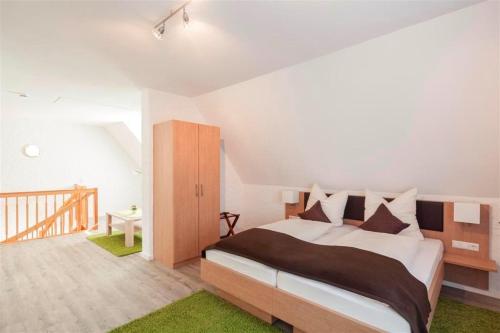 1 dormitorio con 1 cama grande y una escalera en Hotel Garni BURG WALDENSTEIN, en Rudersberg