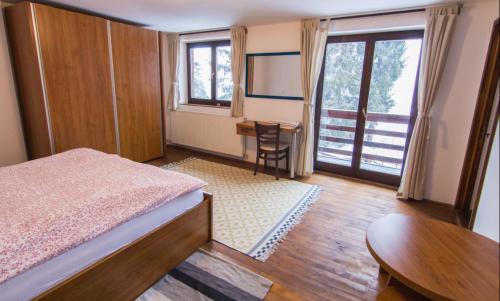 a bedroom with a bed and a desk and a table at Charming Chalet Timisu de Sus in Predeal