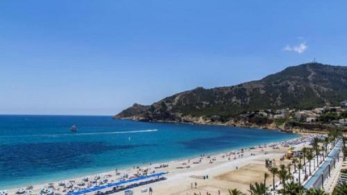 a beach with a bunch of people and the ocean at Ashanti Garden Luxury Short Term Rental Duplex Altea in La Nucía