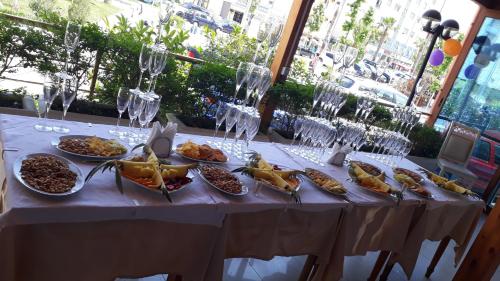 une table blanche avec des assiettes de nourriture dessus dans l'établissement Hotel 3 Vellezerit, à Durrës