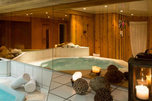 une grande baignoire jacuzzi dans une chambre avec bougies dans l'établissement Chalet-Hôtel La Chemenaz, aux Contamines-Montjoie