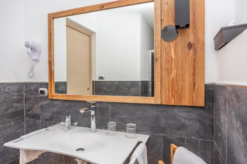 a bathroom with a sink and a mirror at Hotel Chaberton in Cesana Torinese
