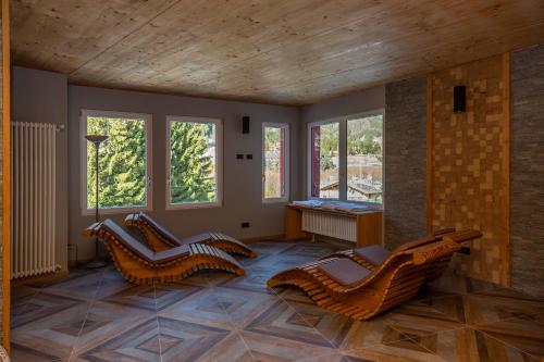 a room with chairs and a table and windows at Hotel Chaberton in Cesana Torinese